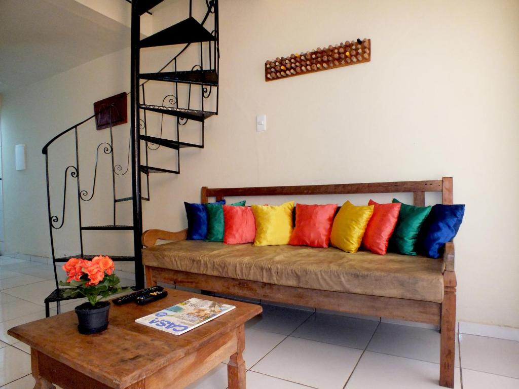 un sofá con almohadas coloridas en una habitación en Sol de Geriba condominio com casas, en Búzios
