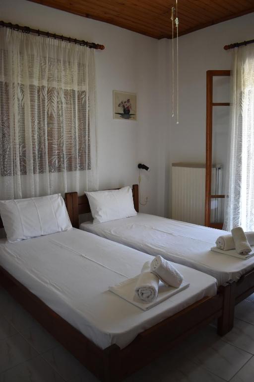 two beds in a bedroom with towels on them at Macrame House Zakynthos in Vasilikos
