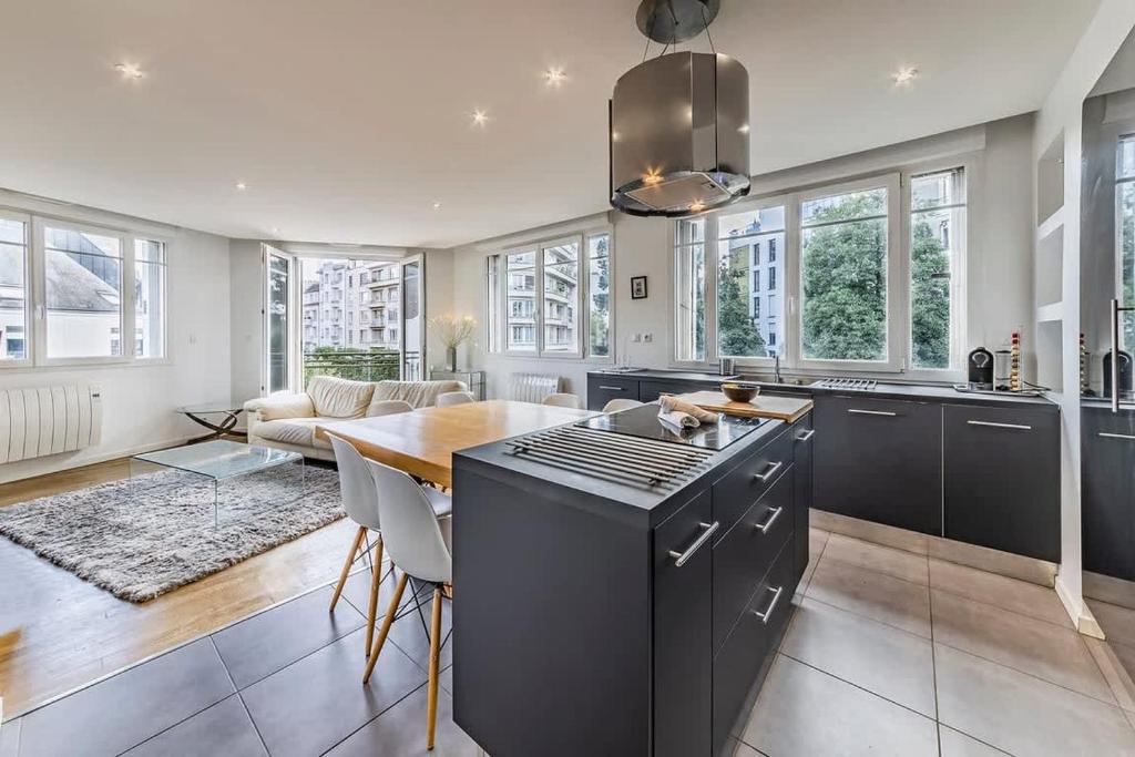 une cuisine avec une table et un comptoir dans l'établissement Le Balzac- 2 chambres - Proche Place de Bretagne, à Rennes