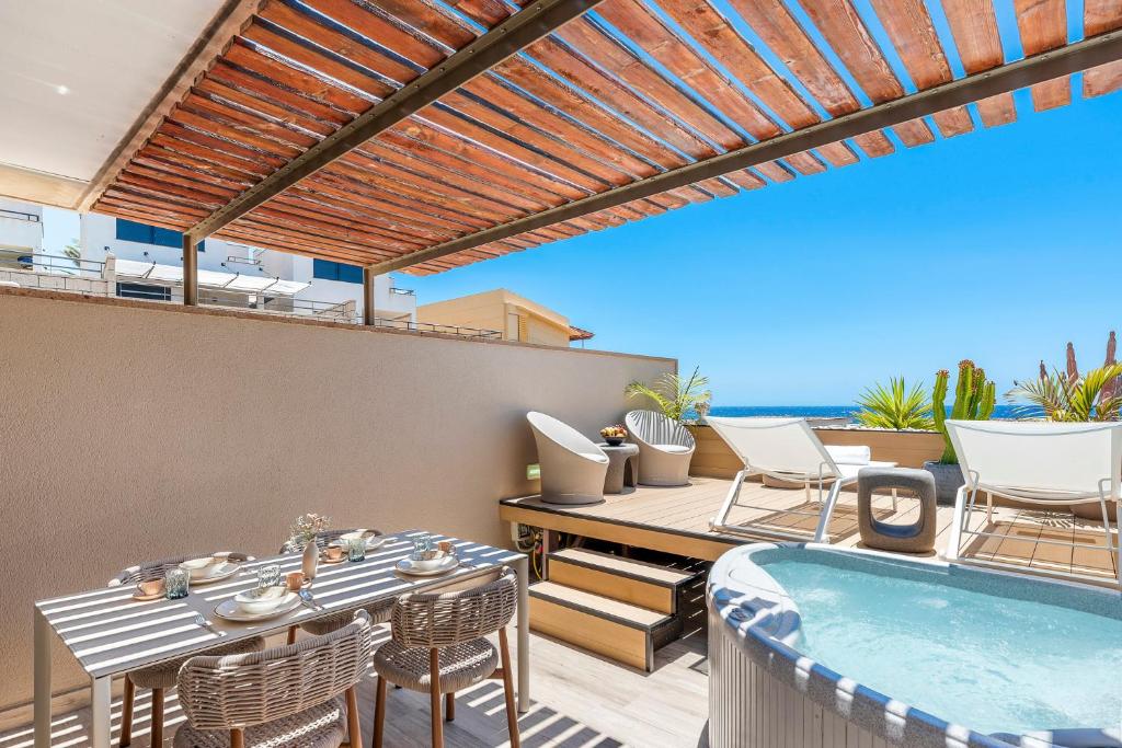 a patio with a table and chairs and a swimming pool at MEDANO4YOU Ocean View Terrace Casa Medano in El Médano