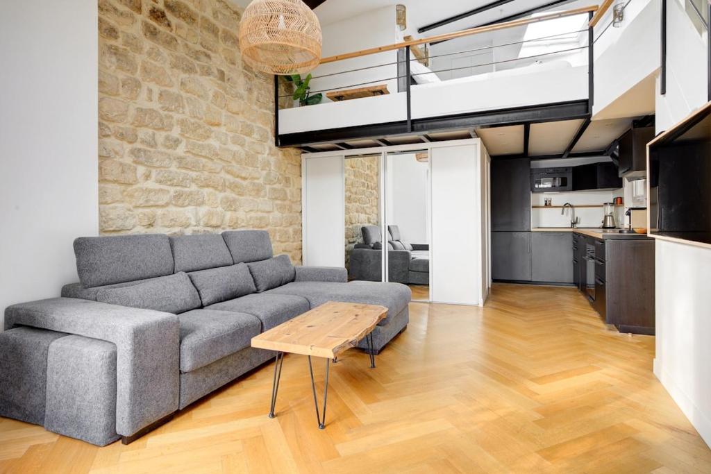 un salon avec un canapé et une mezzanine dans l'établissement Le Loft Montmartre, à Paris