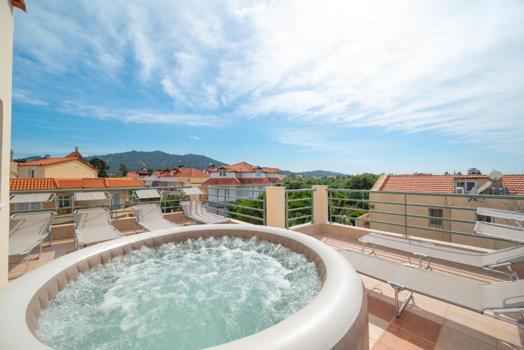 un jacuzzi en el balcón de un edificio en Villa De Ella, en Ialisos