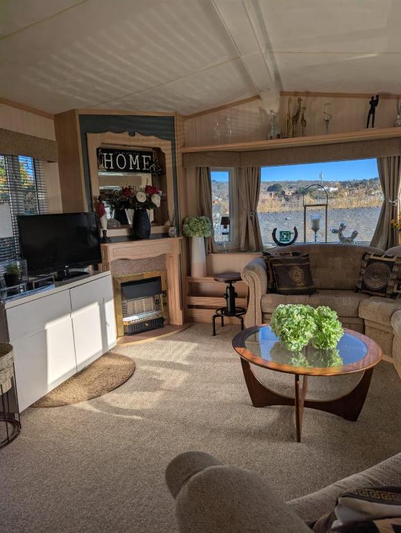 a living room with a couch and a table at Aberystwyth holiday village walking distance to beach, town great outside space parking next to property in Aberystwyth
