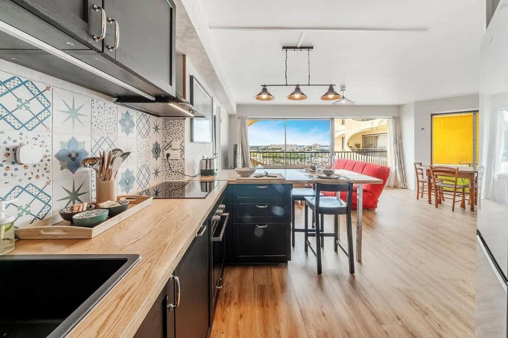 a kitchen with a counter top and a dining room at Bellevue, appartement T2, terrasse & parking in Rennes