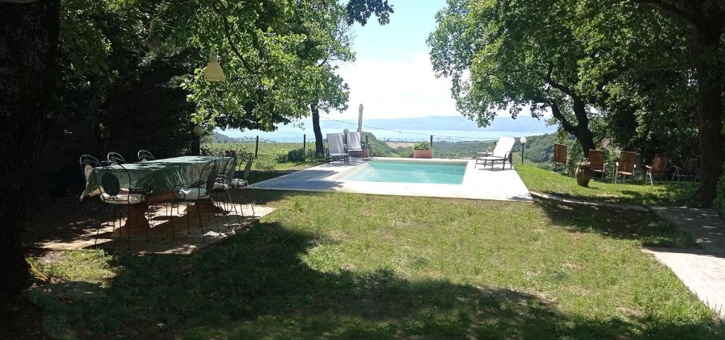a pool with a table and chairs in a yard at Collina delle Rose in Bagnoregio