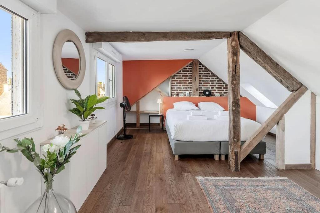une chambre avec un lit blanc et un mur orange dans l'établissement Thabor, beau duplex, 2 chambres, à Rennes