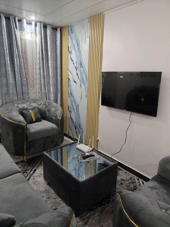 a living room with two couches and a flat screen tv at 2A Appartement KDL in Dakar
