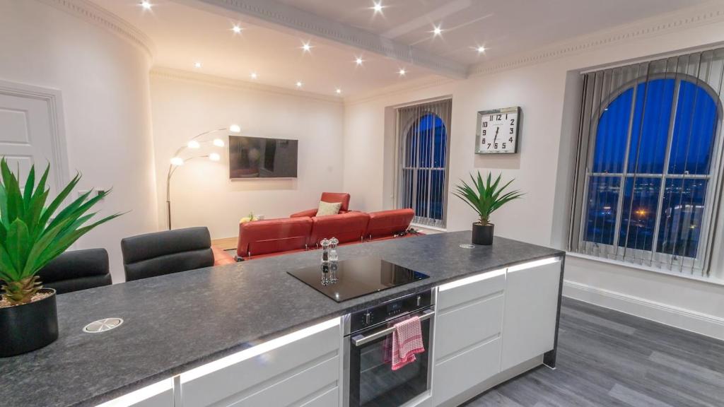 a kitchen with a counter and a living room at Luxury 1 bedroom top floor apartment in Plymouth