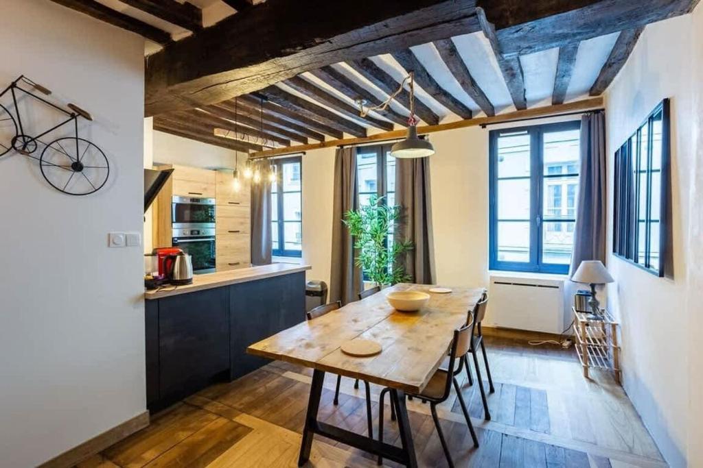Una cocina y un comedor con mesa y sillas de madera. en Le Jacobin, appartement de standing - Hyper centre, en Rennes