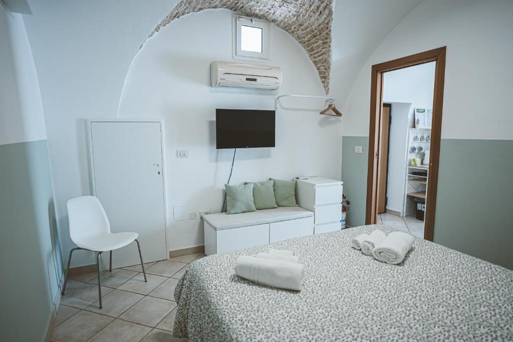a white bedroom with a bed and a chair at Cuore di casa Apartment in Terlizzi