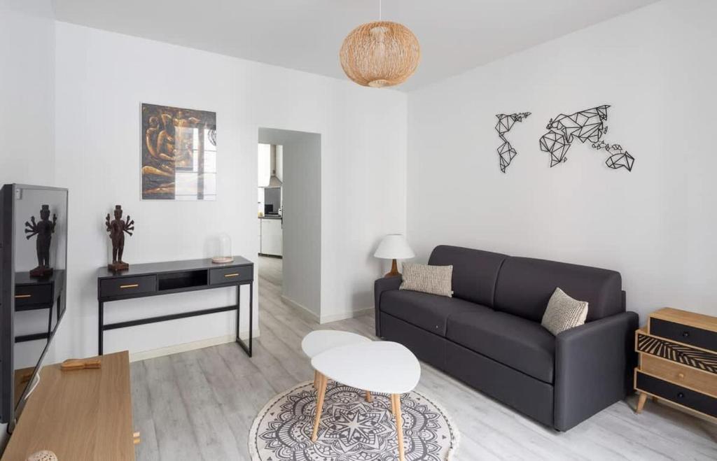 un salon avec un canapé noir et une table dans l'établissement Le Roazhon, hypercentre, moderne et spacieux, à Rennes