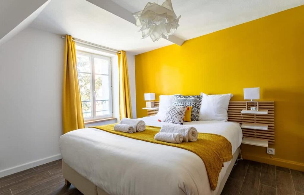 une chambre avec un grand lit avec deux serviettes dessus dans l'établissement Le George V - Beau 2 chambres - Coeur de St Servan, à Saint-Malo