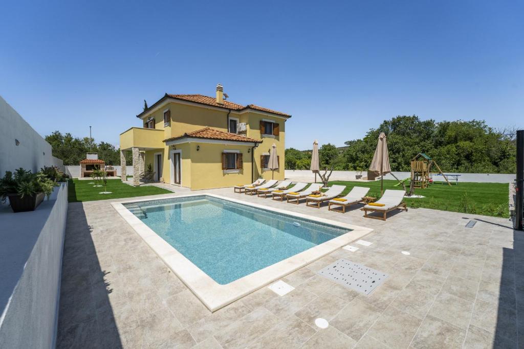 a villa with a swimming pool in front of a house at Beautiful Villa Rustica with pool in Vrana
