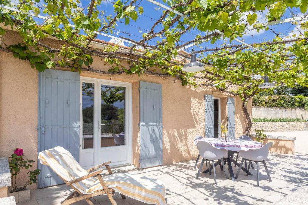 un patio avec une table et des chaises devant une maison dans l'établissement Le Petit Nid, à Saint-Rémy-de-Provence