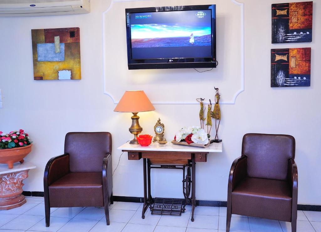 a waiting room with two chairs and a table with a tv at Posidon Studios in Loutra Edipsou