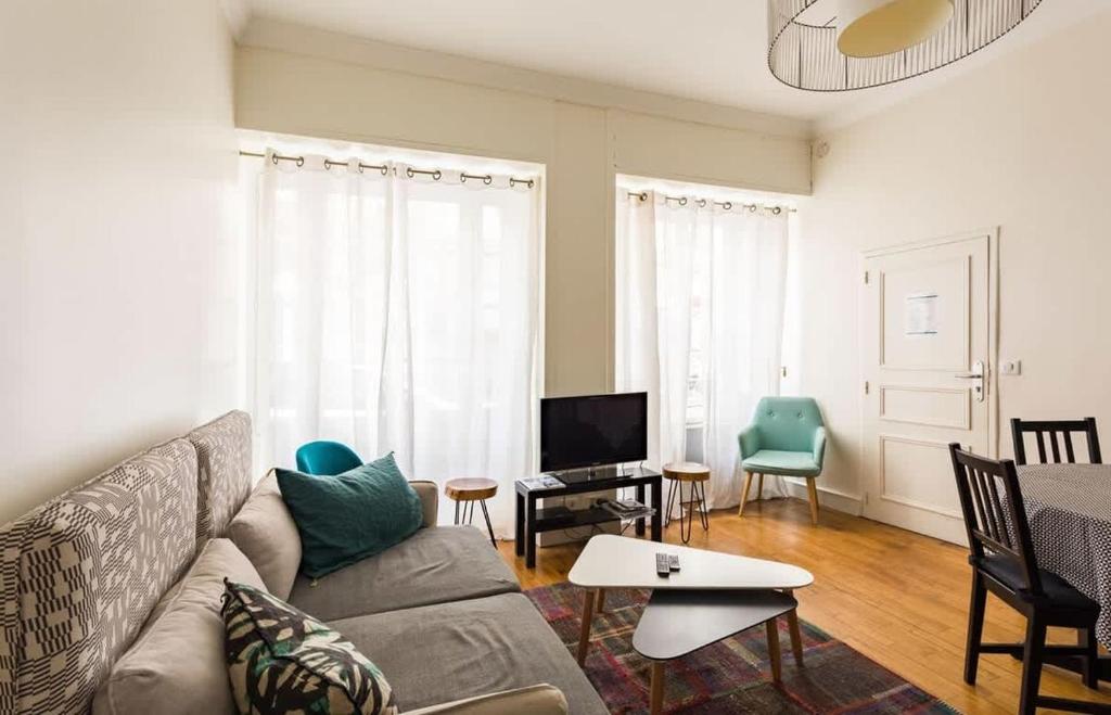 un salon avec un canapé et une télévision dans l'établissement Le Chapitre - Appartement cosy, centre historique, à Rennes