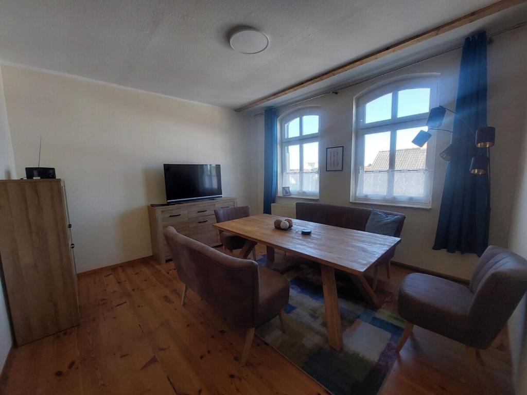 a dining room with a wooden table and chairs at Charmante Monteurwohnung Ferienwohnung bei Berlin, Tesla in Spreenhagen