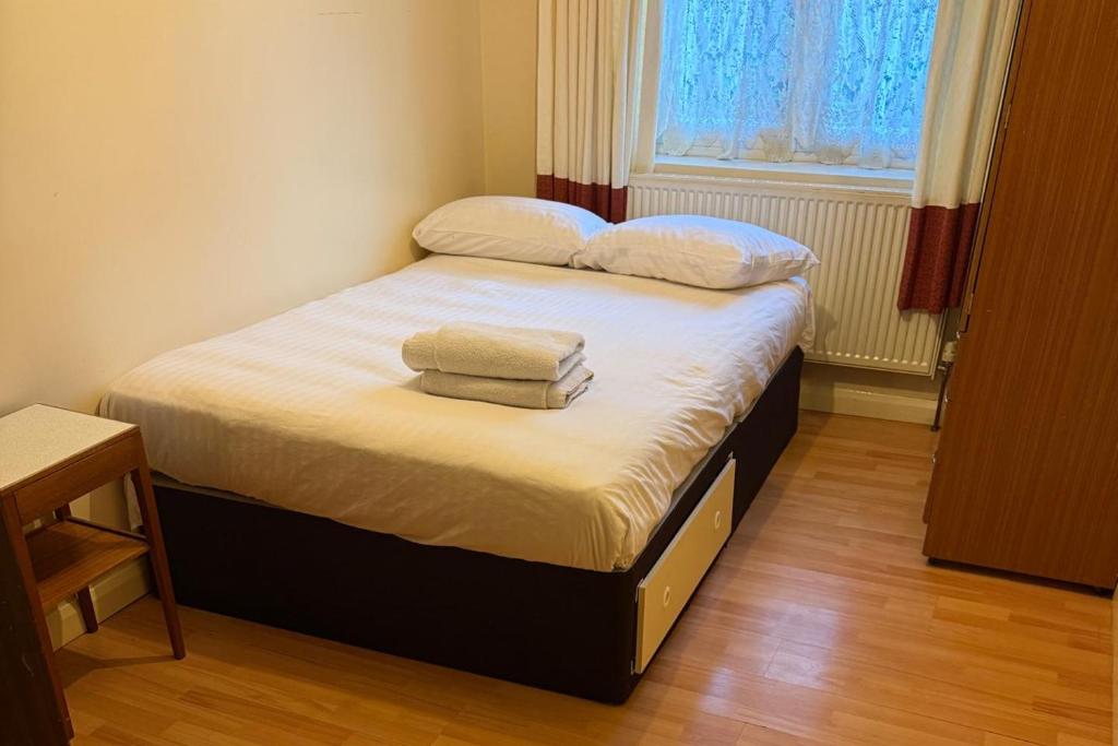 a bed in a room with two towels on it at 2 bed-Sleeps 4-Private Patio-Pets-Near Heathrow in Hounslow