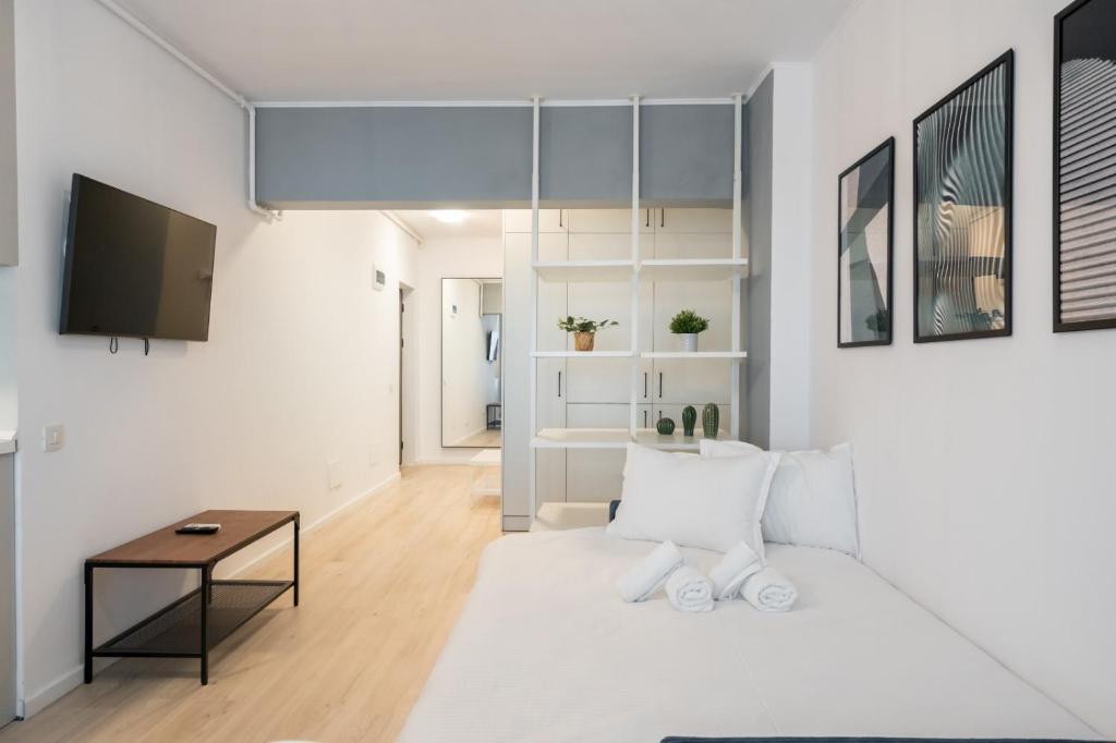 Sala de estar blanca con cama y mesa en High-end Studio with Panoramic View, Parking & Pool, en Bucarest