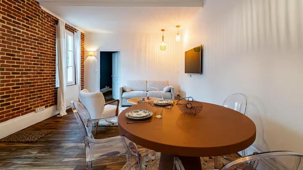 a dining room with a wooden table and chairs at Gare Dijon - Cour Petite Loge in Dijon
