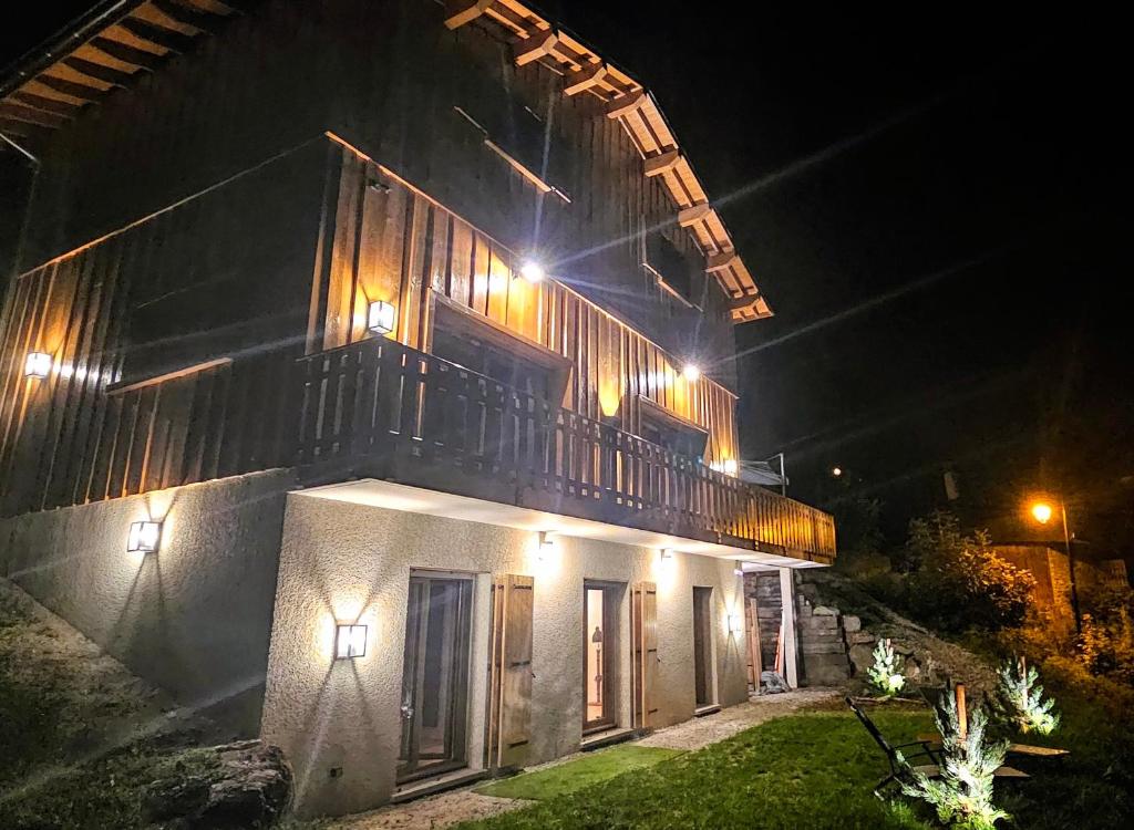 un bâtiment avec un balcon en haut le soir dans l'établissement LatipiK - Chalet à La Plagne, à La Plagne Tarentaise