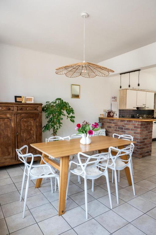 a dining room with a wooden table and chairs at Chez Marraine Suzanne in Liège