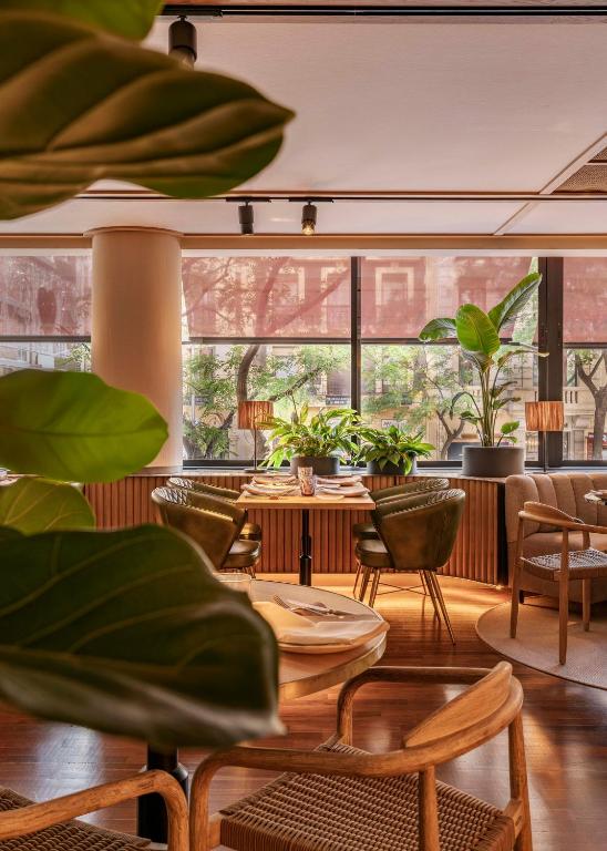 a restaurant with tables and chairs and plants at Vincci Soma in Madrid