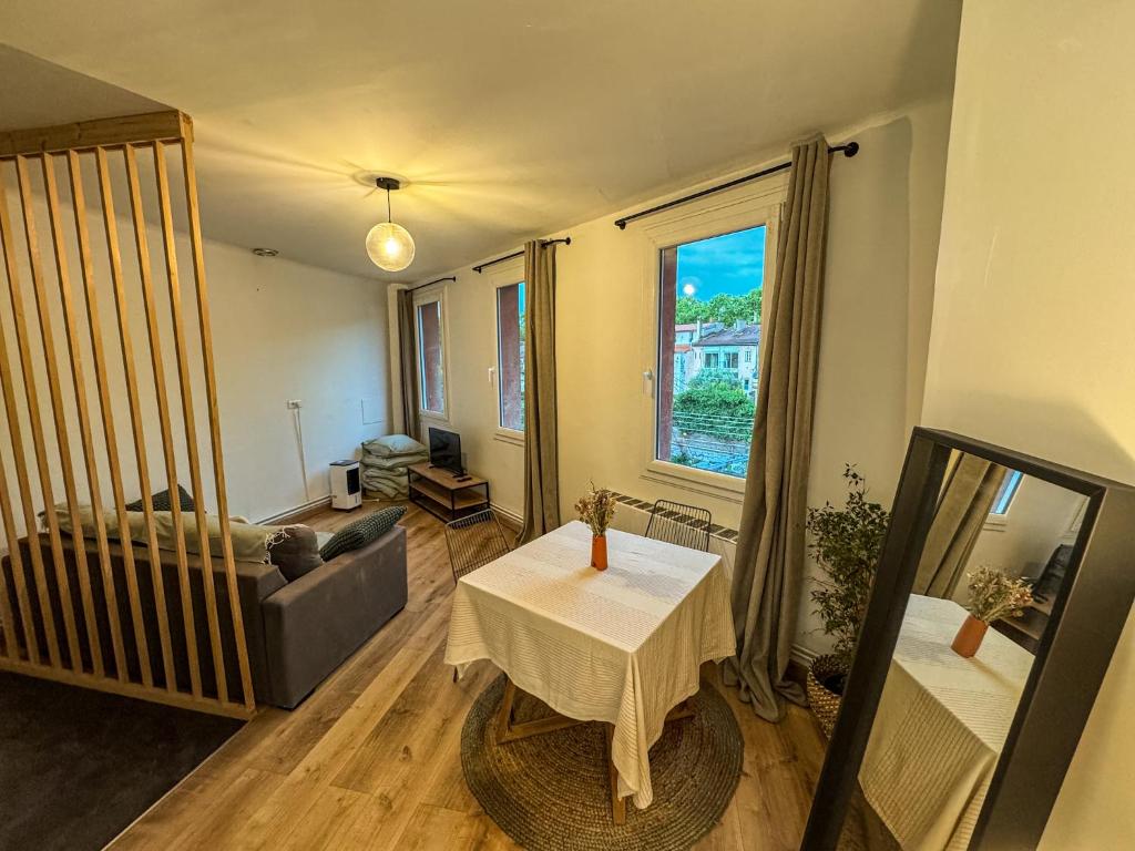 un salon avec un canapé et une table dans l'établissement Cocon Marengo - Studio Cozy de 27m2, à Toulouse