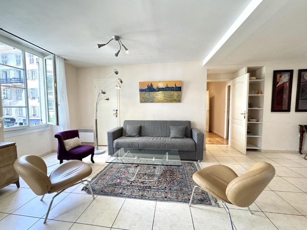 un salon avec un canapé et deux chaises dans l'établissement ApartHotel Riviera - Hotel des Postes 2 - City center Massena, à Nice