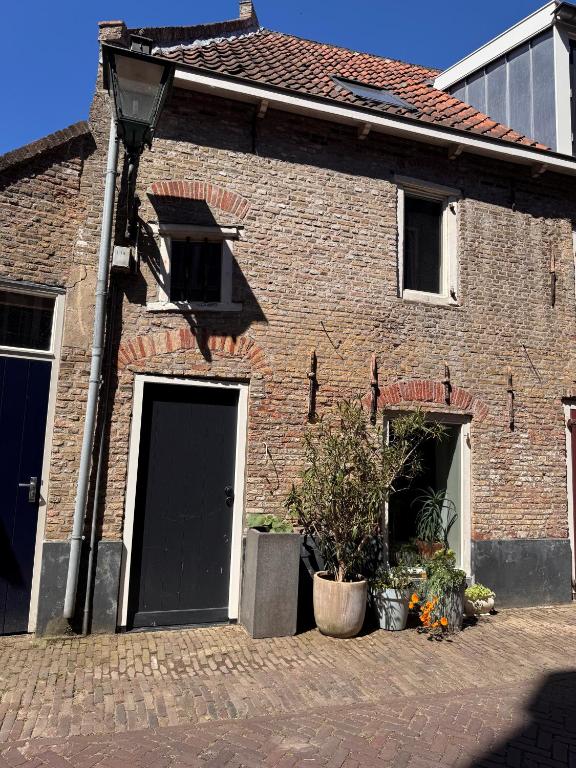 a brick house with a black door and two windows at Slapen in de Paardenstraat in Zierikzee