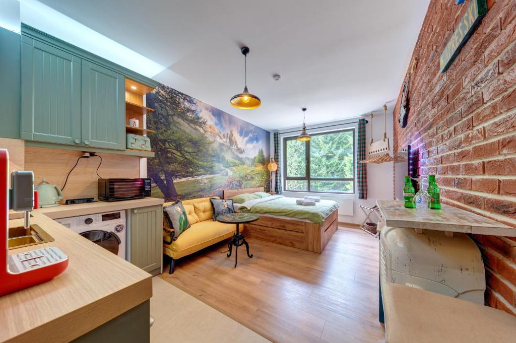 een keuken en een woonkamer met een bank en een bed bij Into the Woods - Charming Studio by Flat Manager in Smolyan