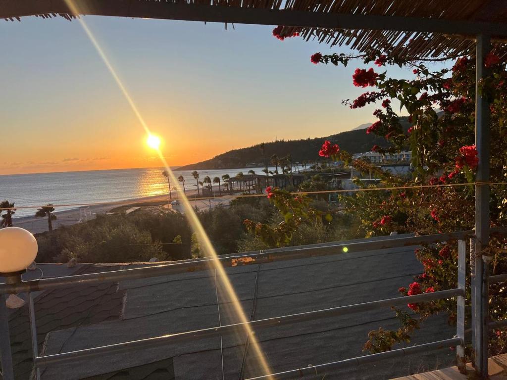 a view of the beach at sunset from a balcony at Blue Marli Rooms in Himare