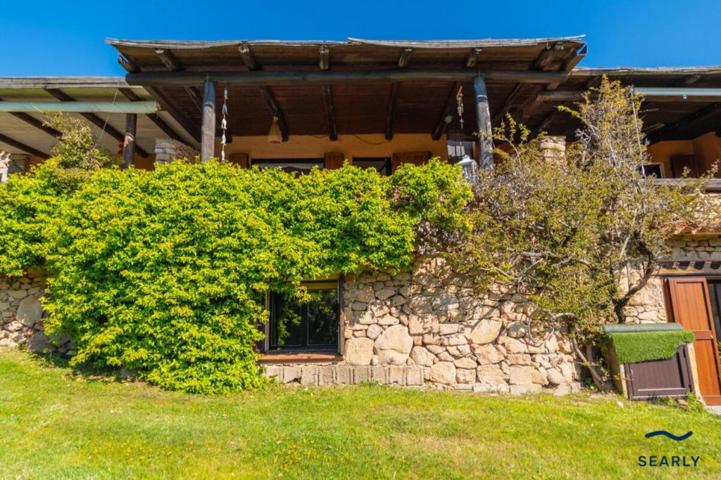 a house with a stone wall and a building at Villa Margherita - By Searly in Porto Rotondo