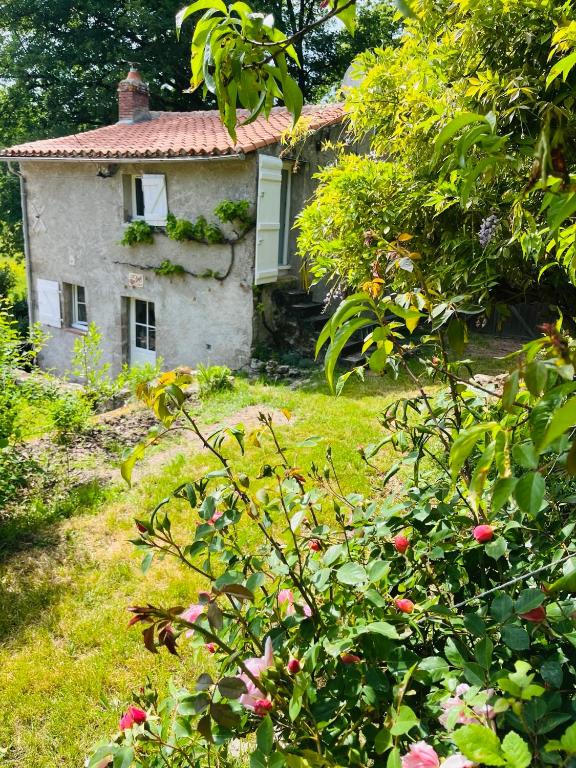 une vieille maison au milieu d'un jardin dans l'établissement Le Logis de Bouchet, à Mortagne-sur-Sèvre