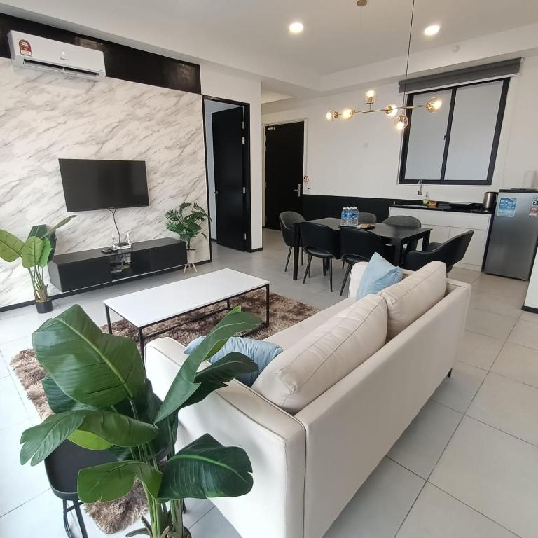 乔治市Urban Suites Georgetown Penang - Sea View & Georgetown View - High Floor - Exclusive & Cozy Stay的客厅里有一张白色的沙发和一张桌子