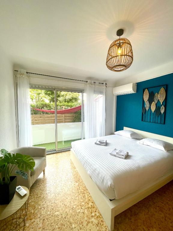 une chambre avec un grand lit avec un mur bleu dans l'établissement La mer, accès direct et calme, terrasse, à Roquebrune-Cap-Martin