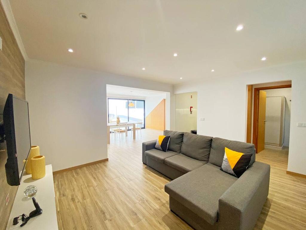 Una sala de estar con un sofá y un televisor. en Casa Trevo de 4 Folhas, en Furnas