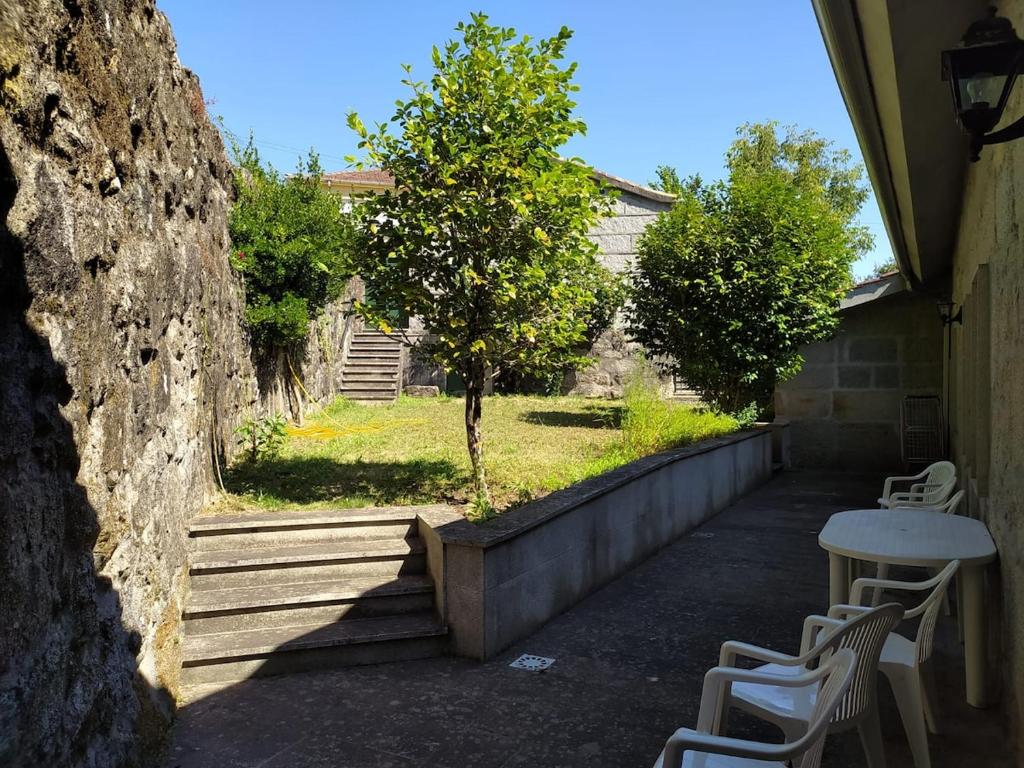 a table and chairs on a patio with a tree at Casa do Poeta in Bubaces