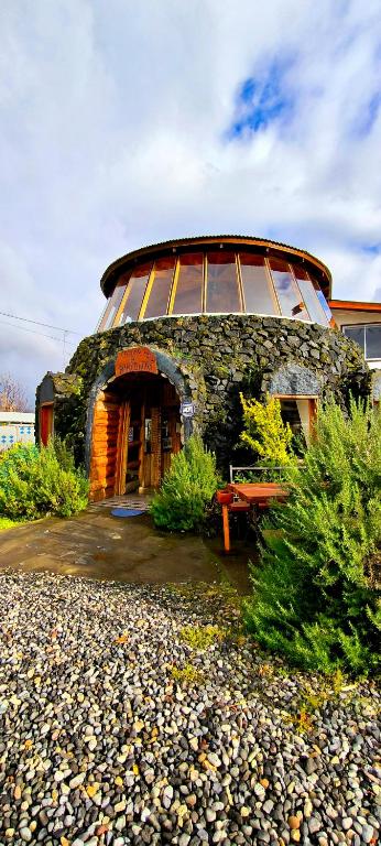 a large stone building with a large window at Hotel Catripulli in Pucón