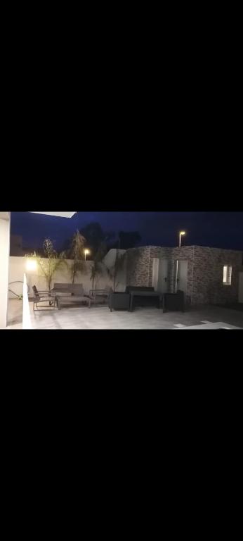un groupe de bancs devant un bâtiment la nuit dans l'établissement Villa dusud perpignan, à Pia