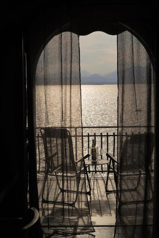 two chairs and a table on the deck of a ship at Casa di Luca in Torri del Benaco