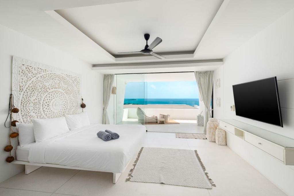 班阁库安Ocean Serenity 3 bd inifity pool with unreal views的白色的客厅配有白色的沙发和平面电视。