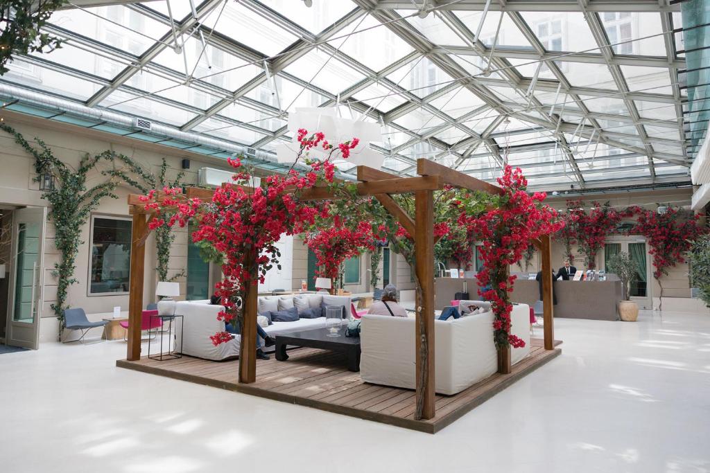 a room filled with furniture and red flowers at Hotel Zenit Budapest Palace in Budapest