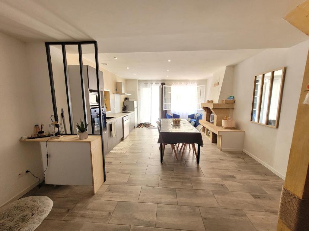 un salon avec une table et une cuisine dans l'établissement Maison au coeur du village de Sérignan 3km de la mer, à Sérignan