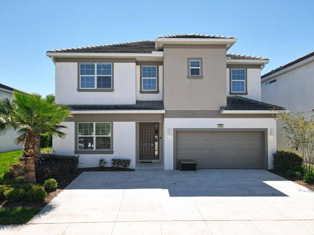 een groot wit huis met een garage bij Experience Villa 12-Bed Vacation Haven BV368 in Kissimmee