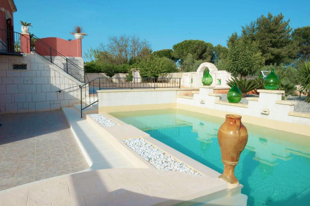 une piscine avec un vase au milieu dans l'établissement Masseria le Colonne del Sole, à Ostuni