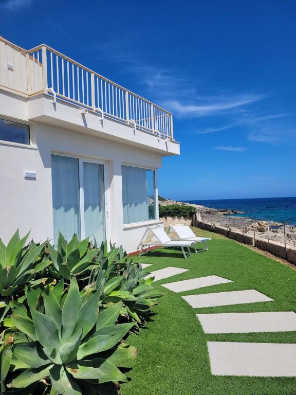 a house on the beach with a lawn at Villa Stella in Fontane Bianche