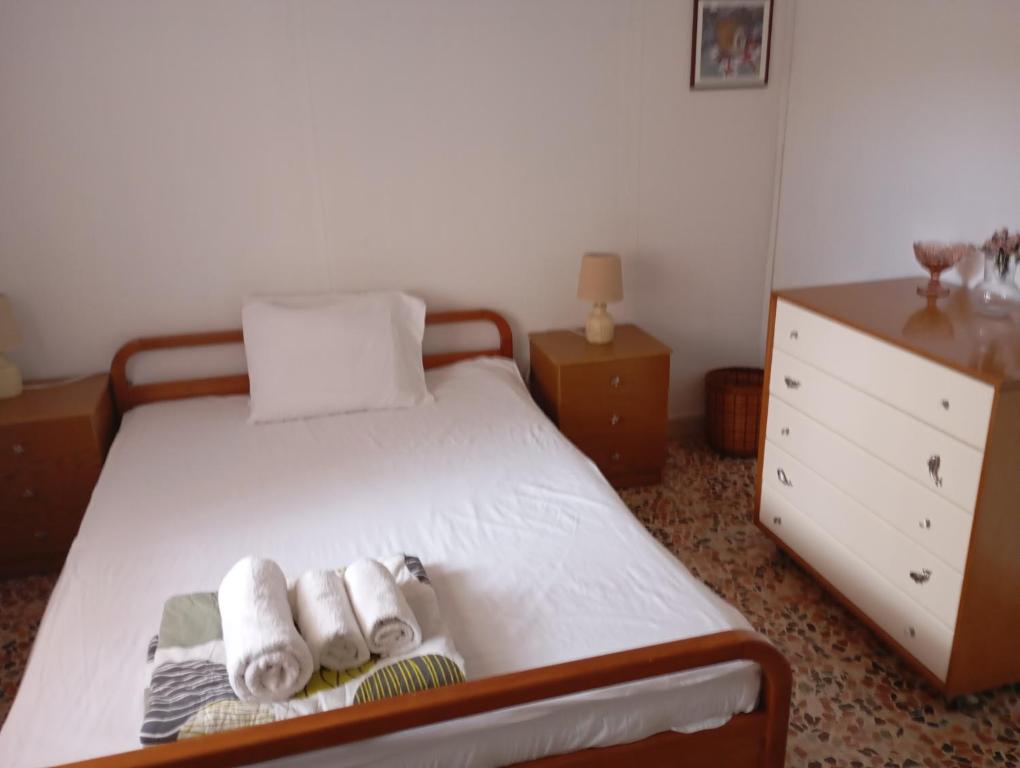 a bedroom with a bed with towels and a dresser at Bamboo garden in Nea Iraklia