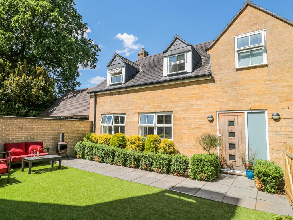 una casa con un jardín delante de ella en The Coach House, en Castle Cary