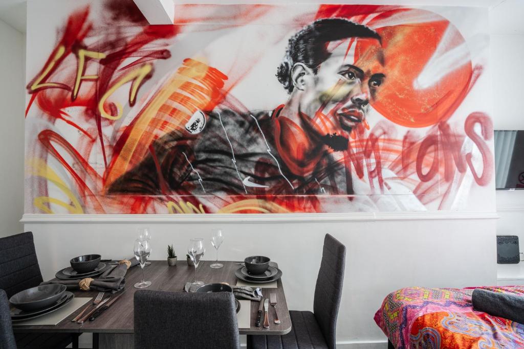 a dining room with a table and a painting on the wall at Anfield Apartments in Liverpool